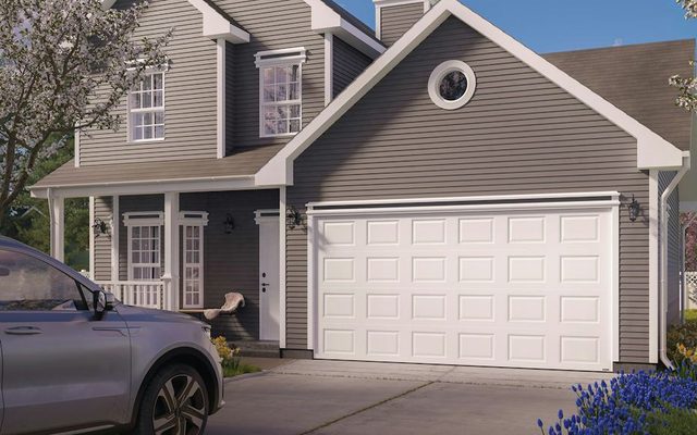 A white Hörmann Therma Tech 3400 raised-panel garage door on a grey two-story house