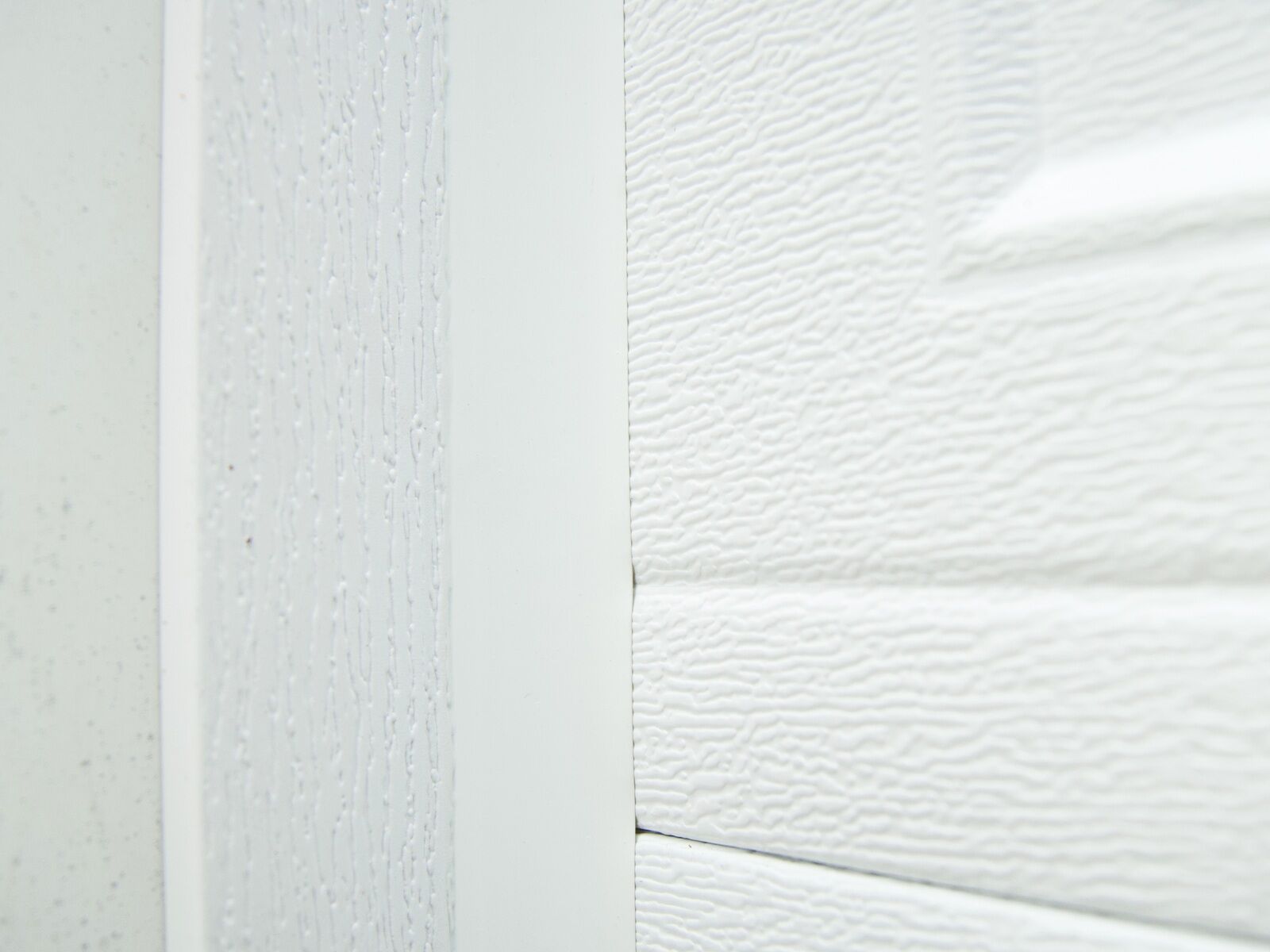 Close-up of a steel garage door panel and its weather seal