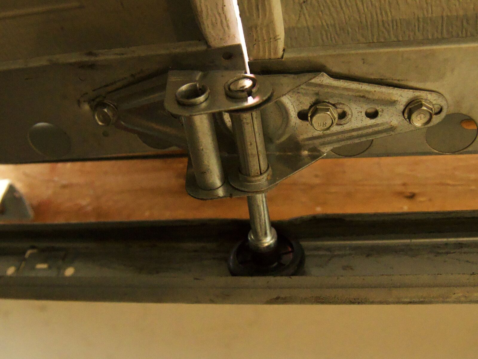 Close-up of a garage door roller bracket and hinge, cleaned and lubricated during a tune-up