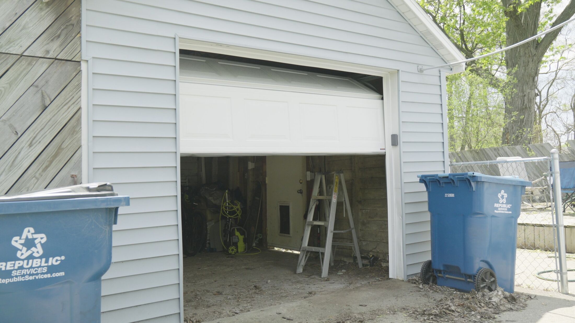 A garage door standing fully open after an after-hours repair call