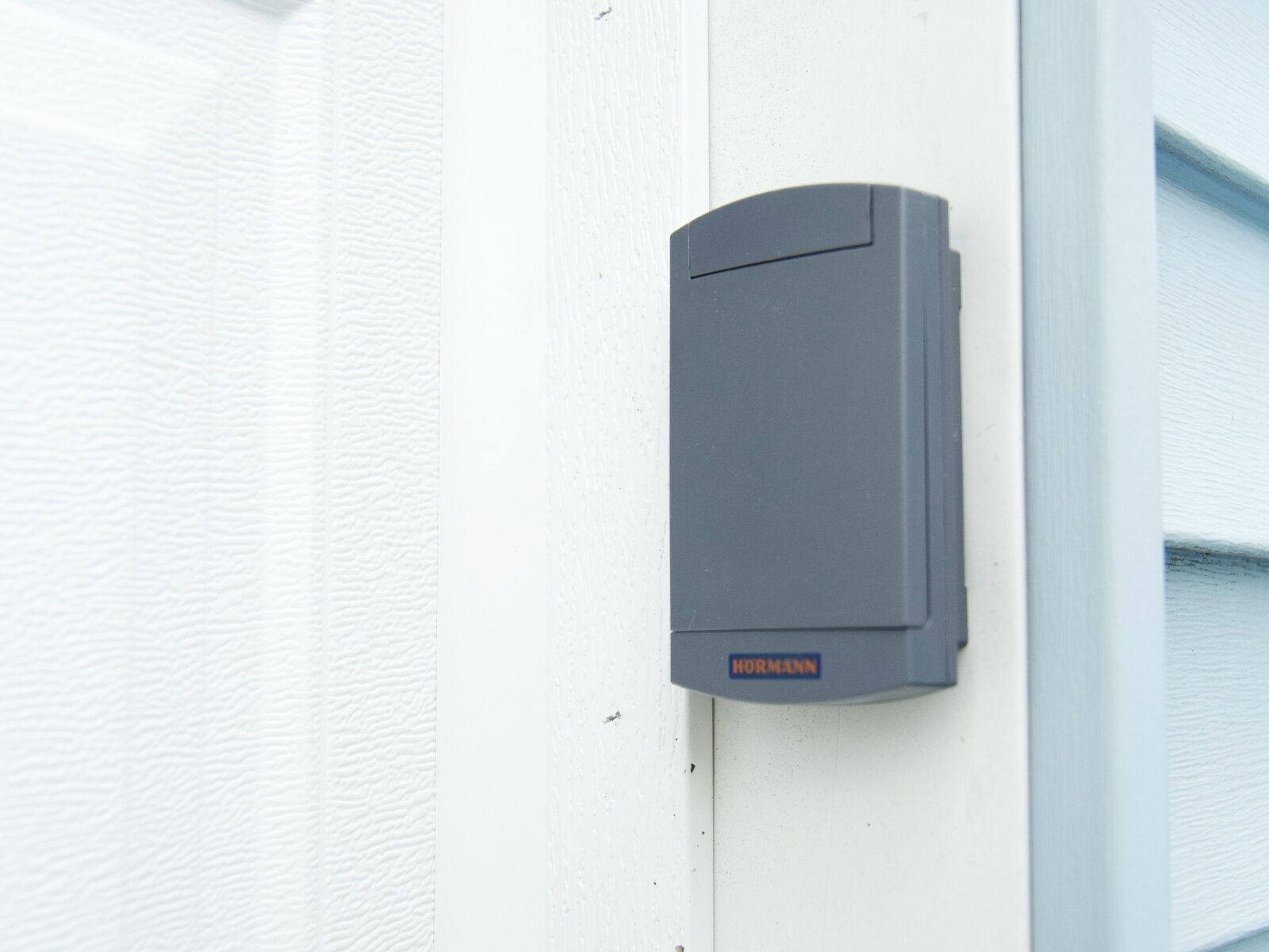 A garage door opener wall control mounted beside the door