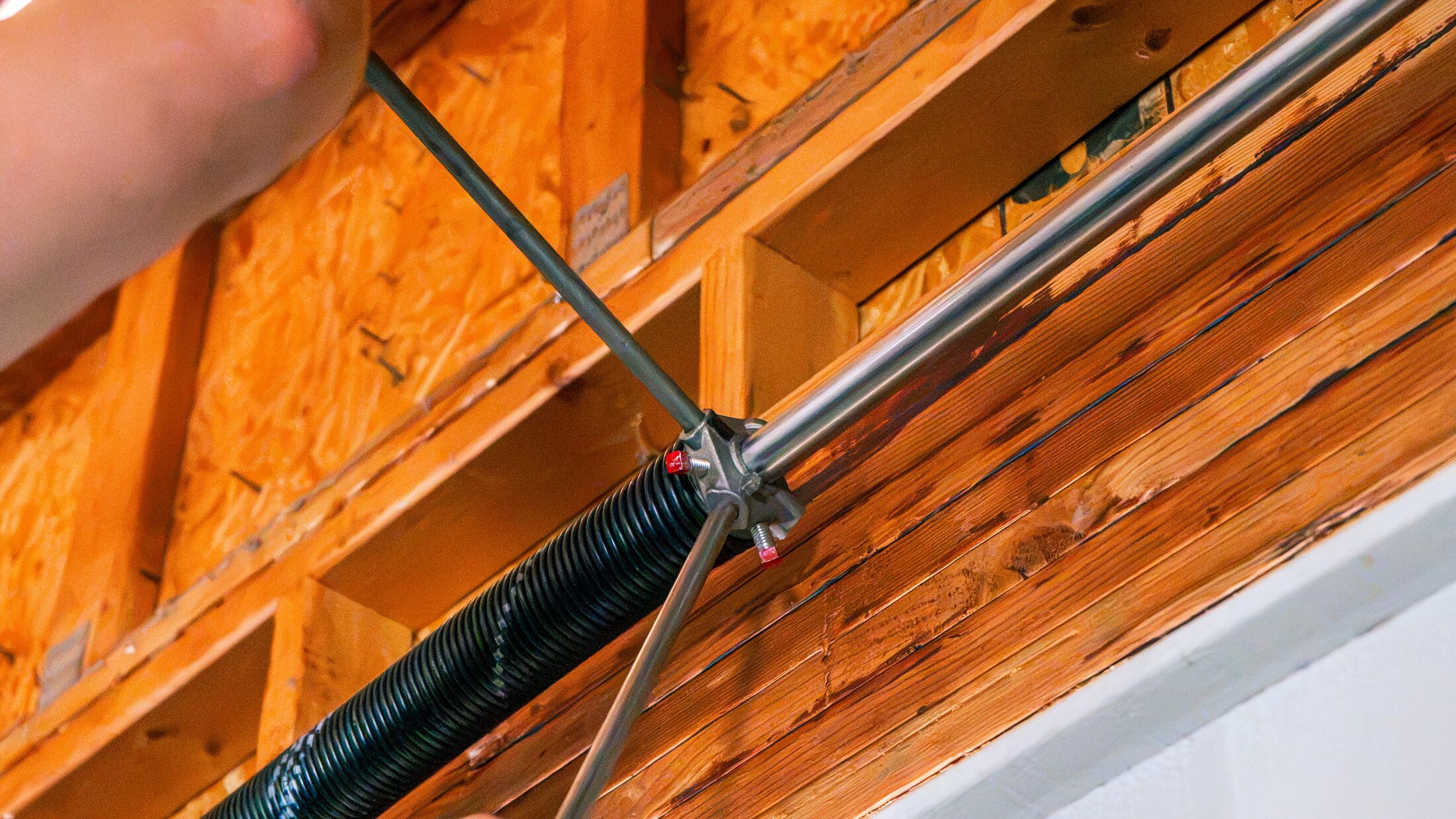 The spring and lift cable running above a garage door, the assembly that carries the door's weight