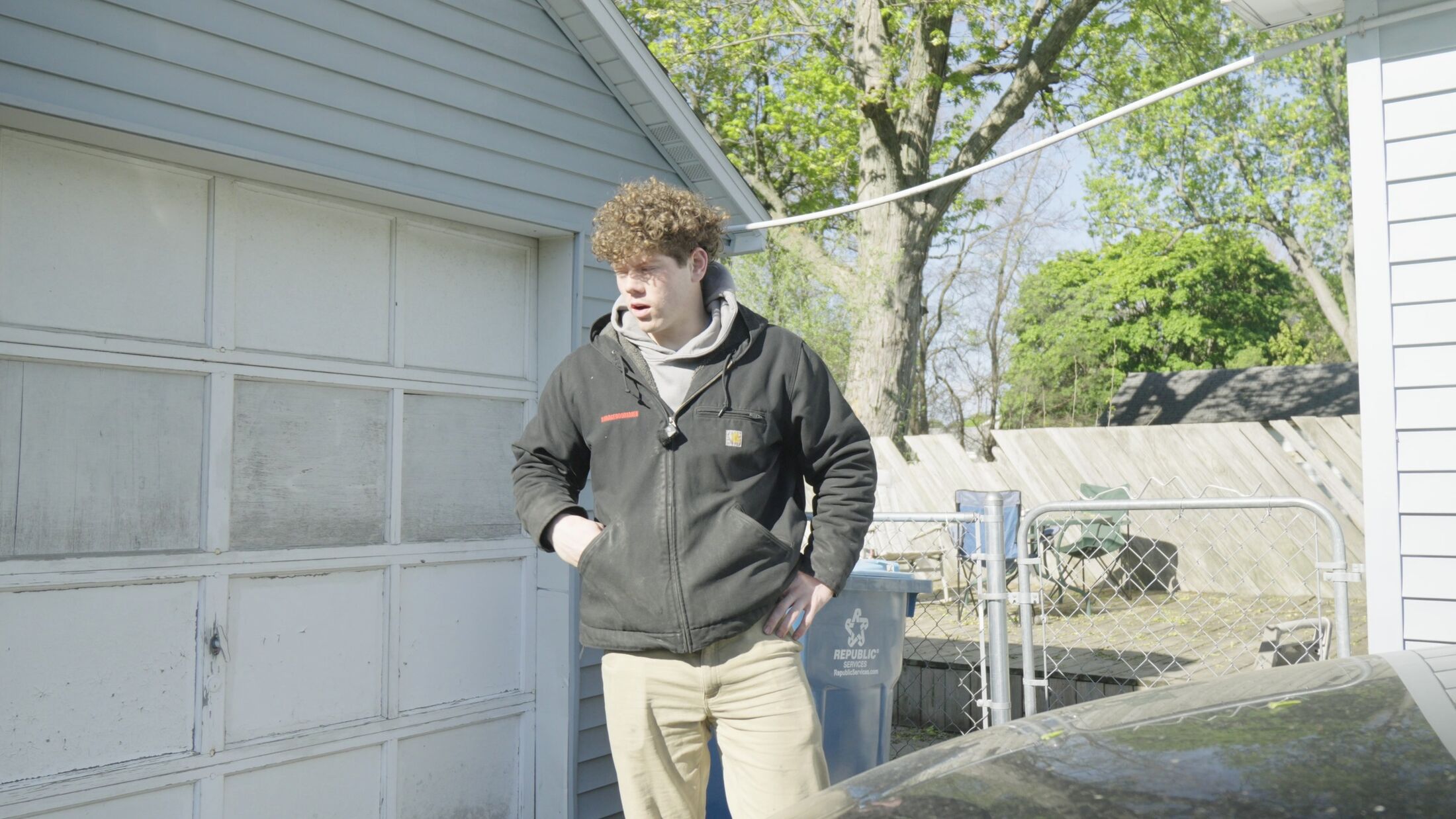 An Elevation technician looking over a failing garage door at a customer's home before quoting the replacement